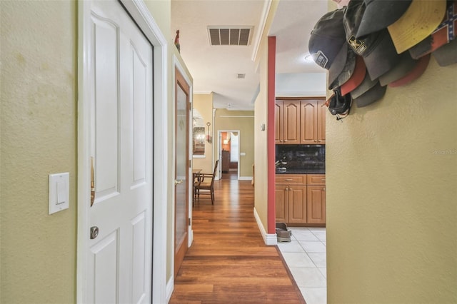 18502 Winding Oaks Blvd, Hudson, FL 34667 - corridor featuring a textured wall, visible vents, and light wood-style flooring