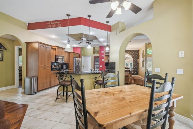 18502 Winding Oaks Blvd, Hudson, FL 34667 - dining area with baseboards, a ceiling fan, arched walkways, and light tile patterned floors