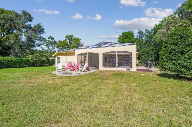 18502 Winding Oaks Blvd, Hudson, FL 34667 - back of house with a patio, glass enclosure, a lawn, and stucco siding