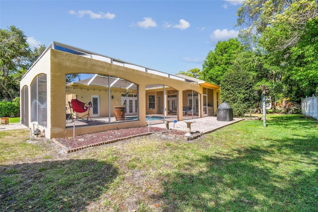 18502 Winding Oaks Blvd, Hudson, FL 34667 - back of property with french doors, a patio, stucco siding, and a yard