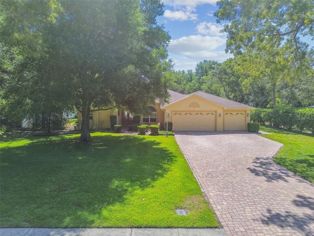 18502 Winding Oaks Blvd, Hudson, FL 34667 - view of front of property with an attached garage, stucco siding, decorative driveway, and a front yard