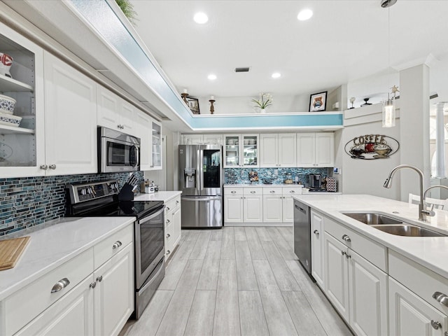 kitchen with backsplash, visible vents, a sink, light countertops, and stainless steel appliances