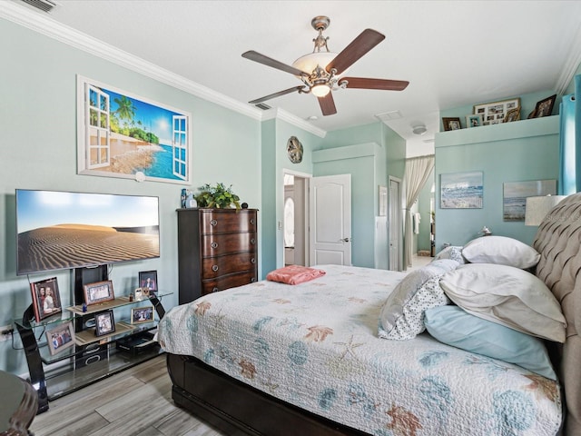 bedroom with crown molding, a ceiling fan, wood finished floors, and visible vents