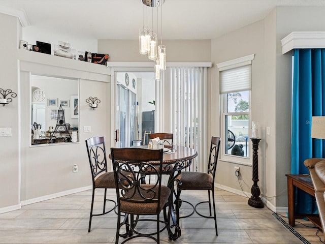 dining space featuring light wood-style floors and baseboards
