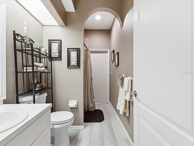 full bath with toilet, a shower with curtain, baseboards, and vanity