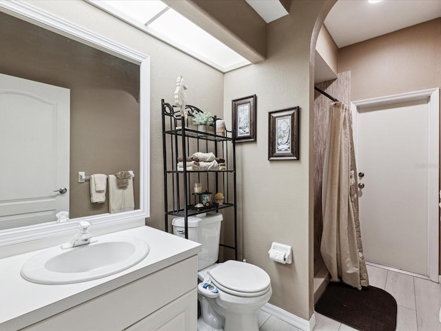 bathroom with toilet, a shower stall, and vanity