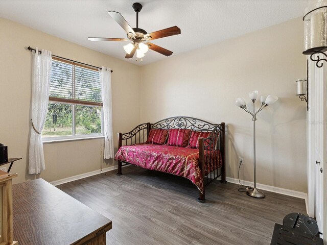 bedroom featuring baseboards, ceiling fan, and wood finished floors