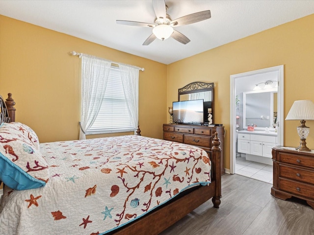 bedroom featuring ensuite bath, wood finished floors, and ceiling fan
