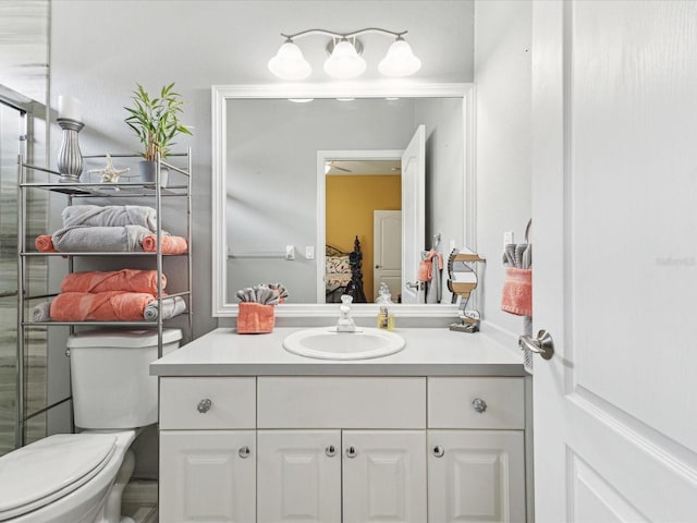 bathroom featuring connected bathroom, toilet, and vanity