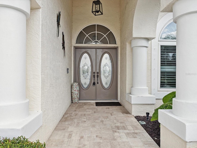 doorway to property featuring stucco siding