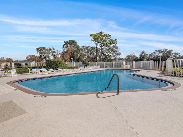 pool with fence and a patio