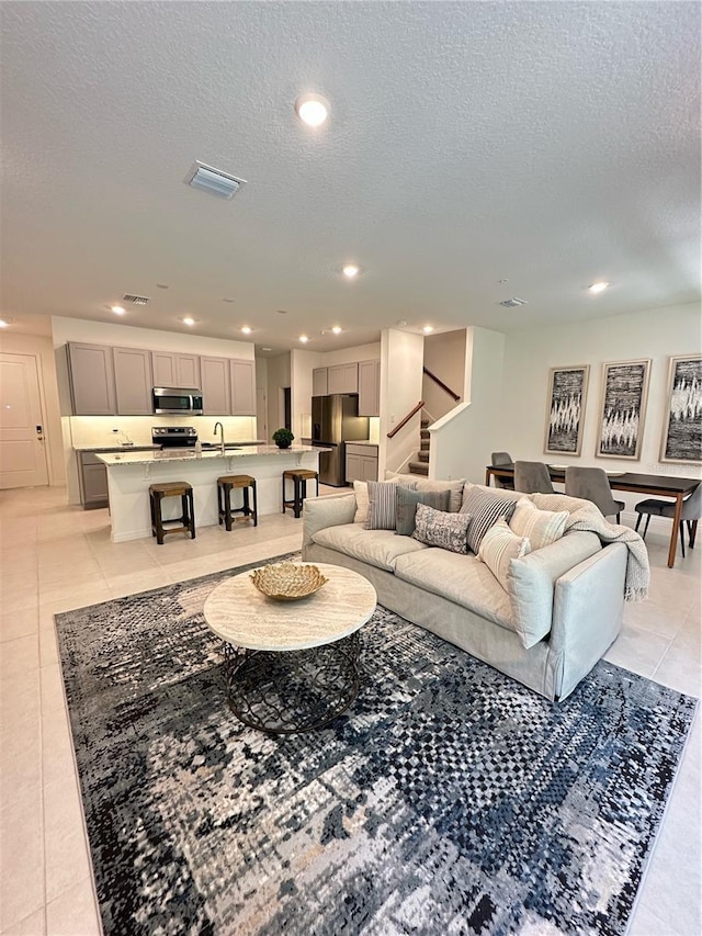 5236 Luisa Ct, Saint Cloud, FL 34771 - living area with light tile patterned floors, a textured ceiling, stairs, and recessed lighting