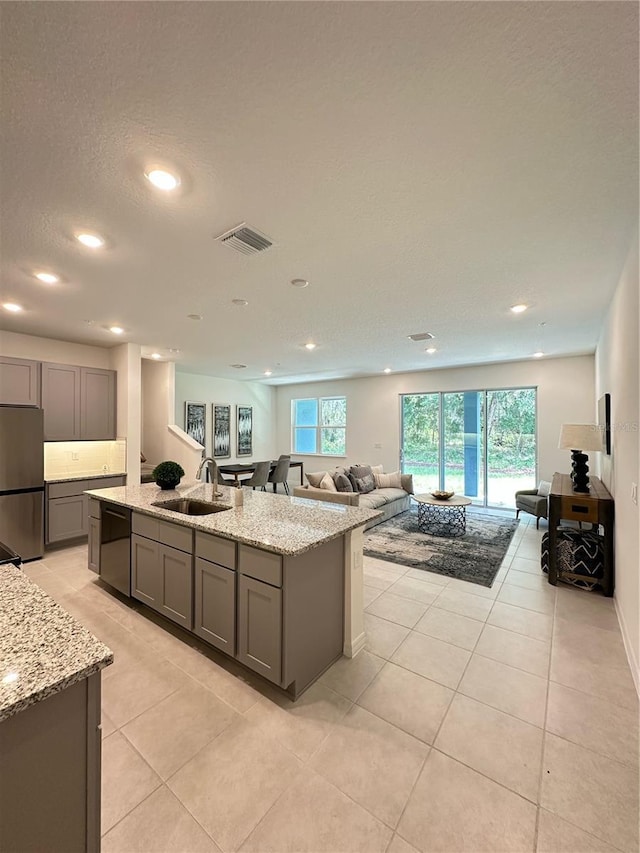 5236 Luisa Ct, Saint Cloud, FL 34771 - kitchen with freestanding refrigerator, a sink, dishwasher, gray cabinets, and an island with sink