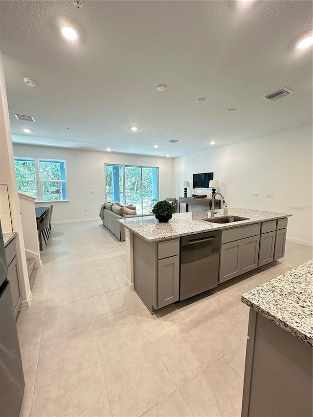 5236 Luisa Ct, Saint Cloud, FL 34771 - kitchen featuring a sink, stainless steel dishwasher, open floor plan, gray cabinetry, and light stone counters