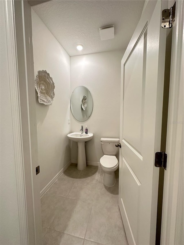 5236 Luisa Ct, Saint Cloud, FL 34771 - half bathroom featuring toilet, tile patterned floors, a textured ceiling, and baseboards