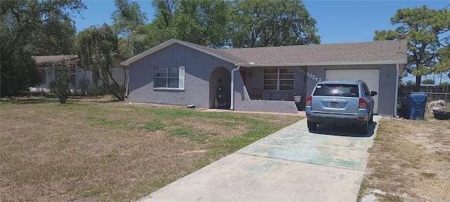 single story home with a garage, a front lawn, stucco siding, and concrete driveway