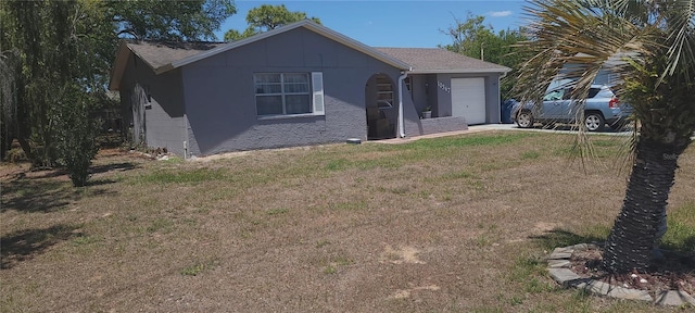 view of front of house featuring driveway, a shingled roof, a front yard, and a garage