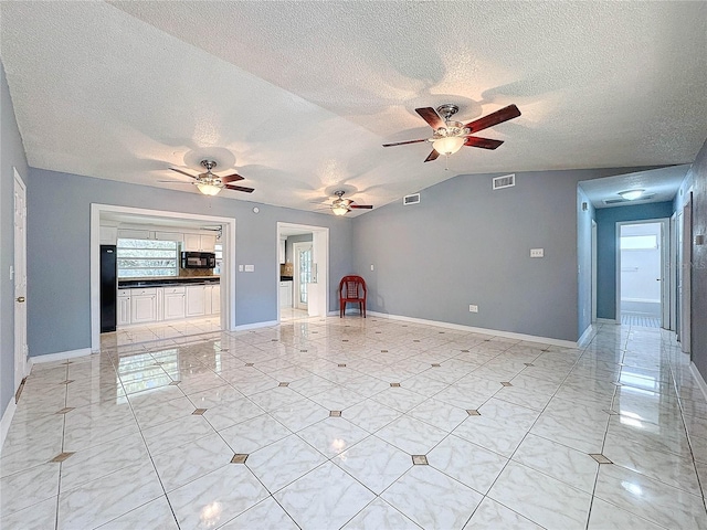 5147 Larch Ln, New Port Richey, FL 34653 - unfurnished living room with a ceiling fan, a textured ceiling, visible vents, and vaulted ceiling