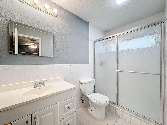 5147 Larch Ln, New Port Richey, FL 34653 - bathroom with vanity, toilet, tile walls, tile patterned floors, and a stall shower