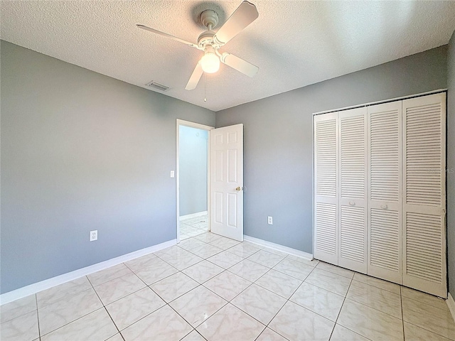 5147 Larch Ln, New Port Richey, FL 34653 - unfurnished bedroom featuring a ceiling fan, a textured ceiling, visible vents, light tile patterned floors, and a closet