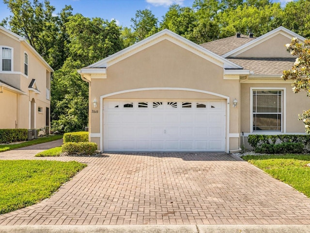 7616 Wimpole Dr, New Port Richey, FL 34655 - view of front of property with stucco siding, a shingled roof, decorative driveway, central air condition unit, and an attached garage