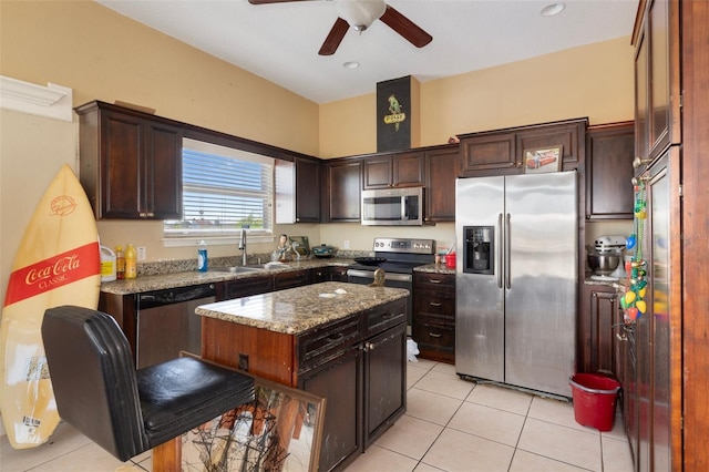 13810 Celida Ave, Hudson, FL 34667 - kitchen with light stone counters, appliances with stainless steel finishes, ceiling fan, a sink, and light tile patterned flooring