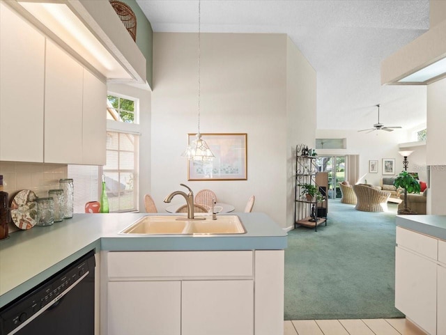 kitchen with light carpet, dishwasher, a sink, a peninsula, and open floor plan