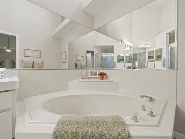 full bathroom featuring a bath, a shower stall, and vanity