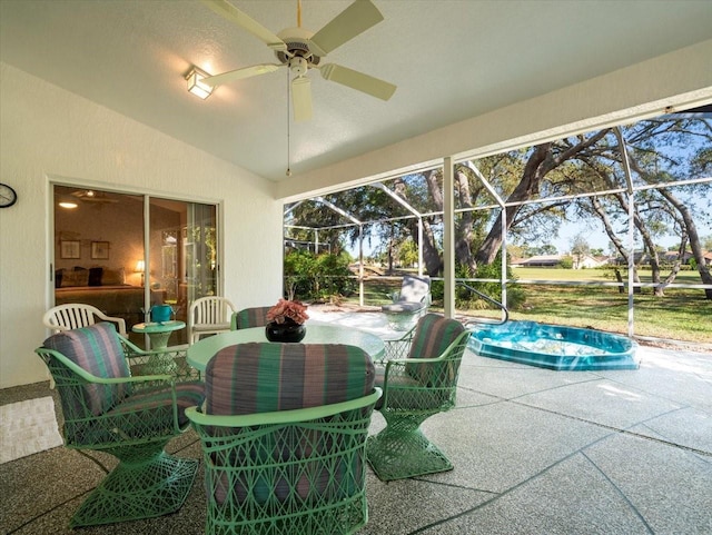 sunroom / solarium with ceiling fan, outdoor dining area, and a swimming pool