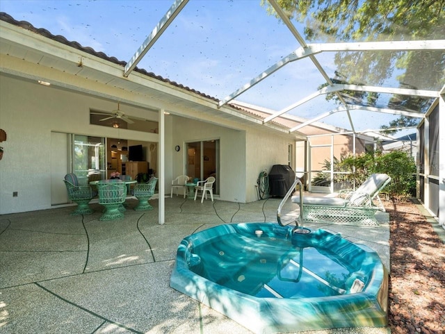 view of patio with ceiling fan, glass enclosure, and area for grilling