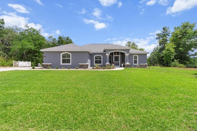 view of front of house with a front yard and stucco siding