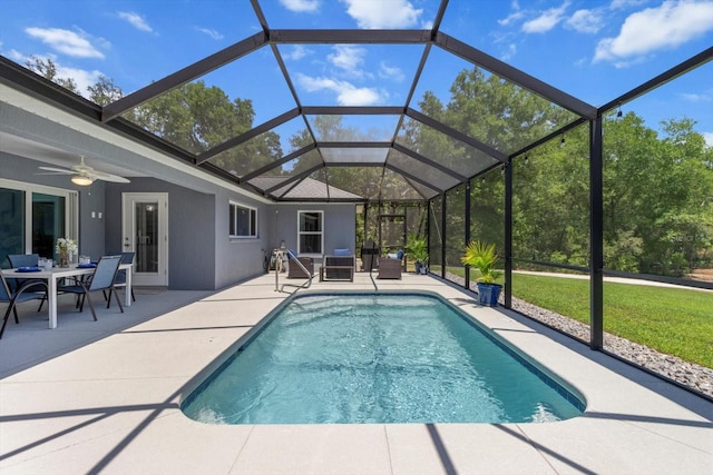pool with a patio, a ceiling fan, and glass enclosure