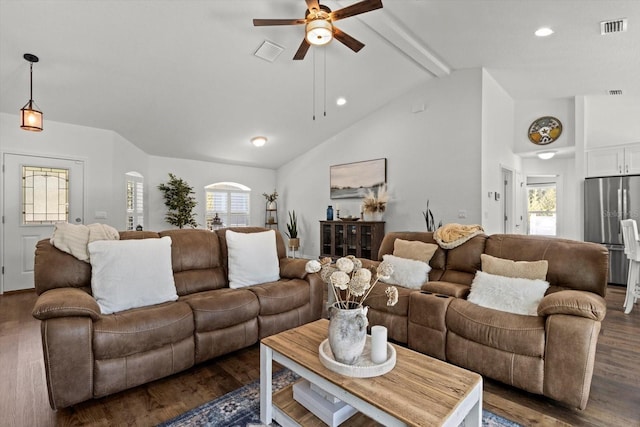 living area featuring a healthy amount of sunlight, vaulted ceiling with beams, ceiling fan, and visible vents