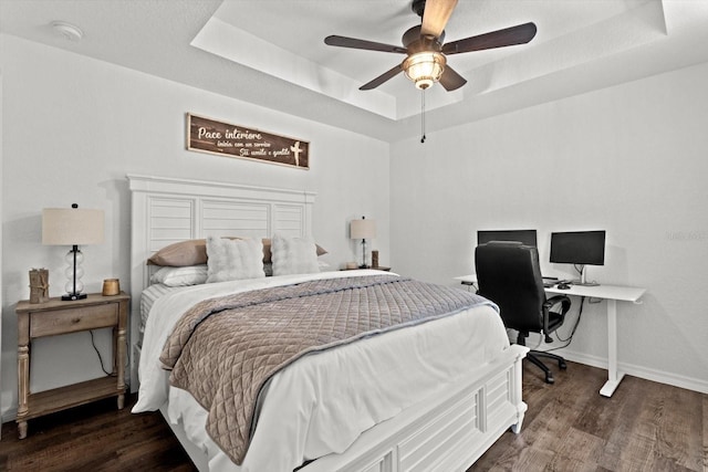 bedroom with a raised ceiling, baseboards, a ceiling fan, and wood finished floors