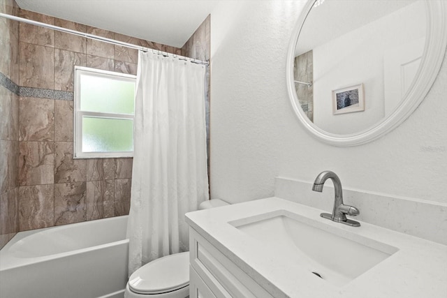 bathroom featuring vanity, toilet, a textured wall, and shower / tub combo