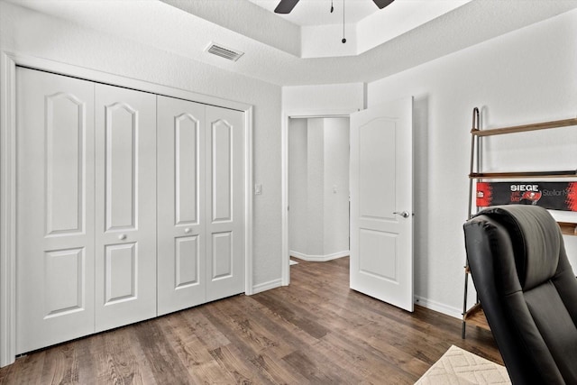 office with visible vents, a ceiling fan, baseboards, and wood finished floors