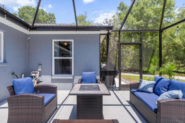 exterior space featuring glass enclosure and an outdoor fire pit