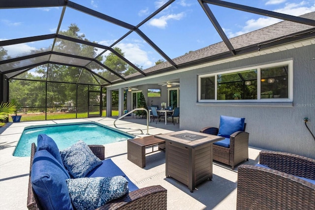 outdoor pool featuring glass enclosure, ceiling fan, a patio area, and an outdoor living space with a fire pit