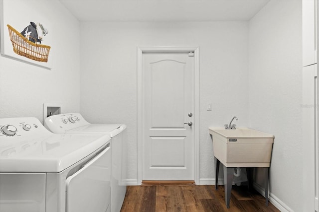 laundry area with laundry area, dark wood finished floors, washing machine and dryer, and baseboards