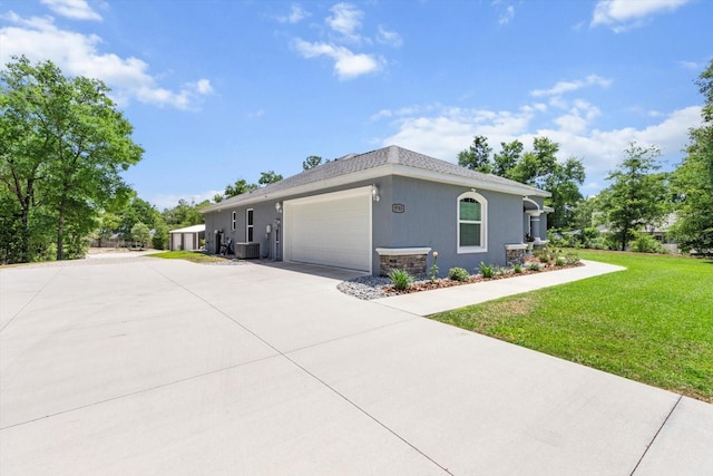 view of side of home featuring a lawn, central air condition unit, an attached garage, and driveway