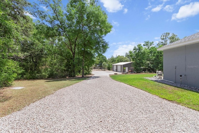exterior space featuring a yard, driveway, and an outdoor structure