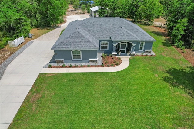 view of front facade featuring driveway, a shingled roof, a front yard, and stucco siding