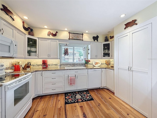 75 N Canal Dr, Palm Harbor, FL 34684 - kitchen with white appliances, backsplash, a sink, and light wood-style flooring