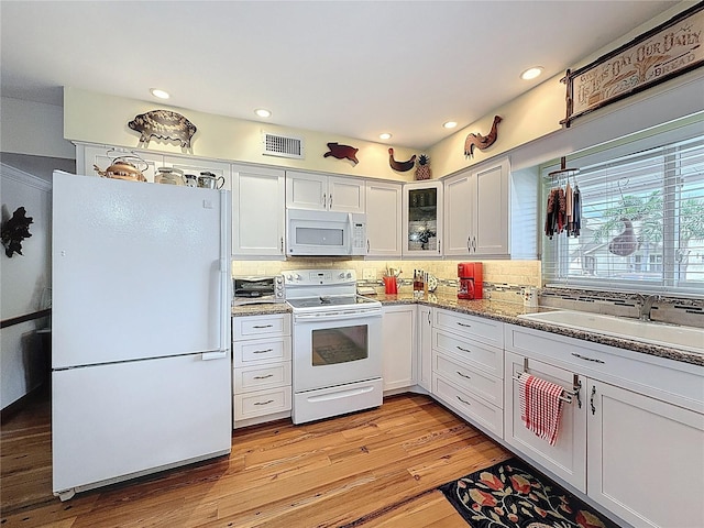 75 N Canal Dr, Palm Harbor, FL 34684 - kitchen with white appliances, visible vents, a sink, and tasteful backsplash