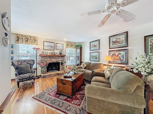75 N Canal Dr, Palm Harbor, FL 34684 - living area with a fireplace with raised hearth, ceiling fan, a healthy amount of sunlight, and hardwood / wood-style flooring