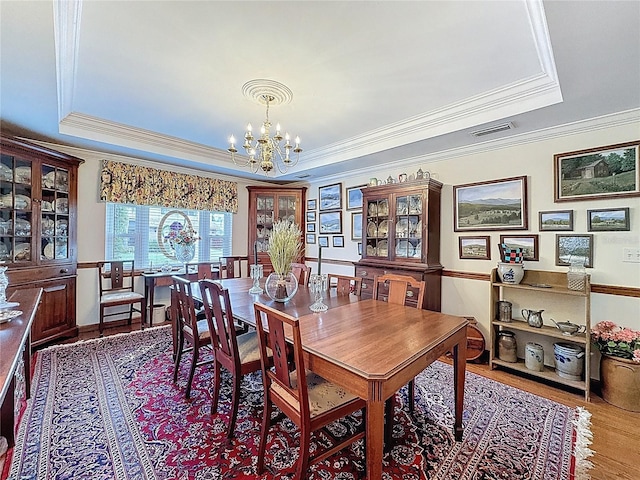 75 N Canal Dr, Palm Harbor, FL 34684 - dining room with visible vents, a raised ceiling, crown molding, and a notable chandelier