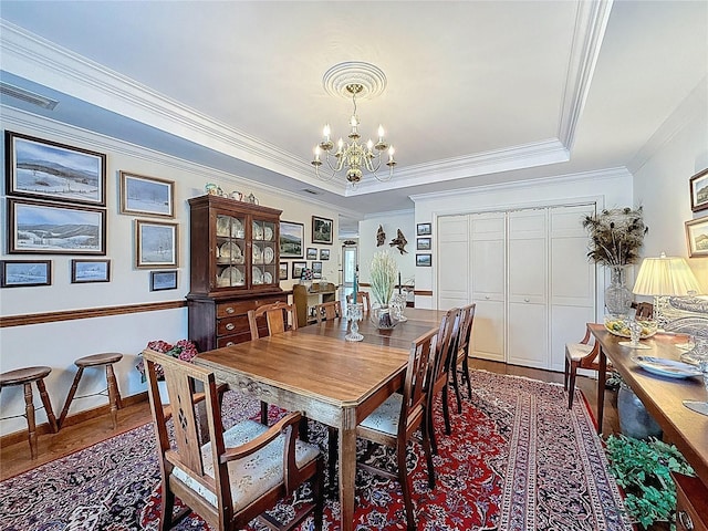 75 N Canal Dr, Palm Harbor, FL 34684 - dining area with an inviting chandelier, ornamental molding, a raised ceiling, and wood finished floors