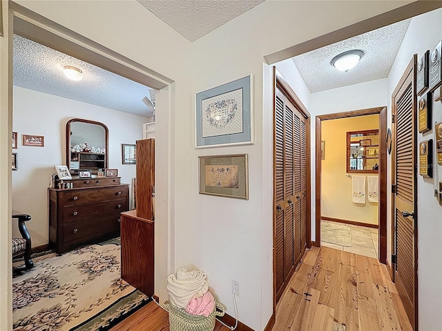 75 N Canal Dr, Palm Harbor, FL 34684 - corridor with baseboards, a textured ceiling, and light wood-style flooring