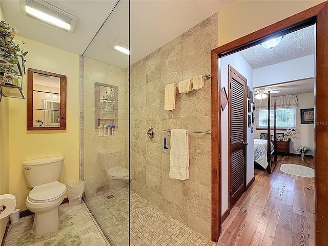 75 N Canal Dr, Palm Harbor, FL 34684 - full bathroom with wood finished floors, toilet, baseboards, a walk in shower, and ensuite bath
