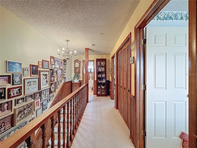 75 N Canal Dr, Palm Harbor, FL 34684 - corridor featuring lofted ceiling, light carpet, a textured ceiling, a chandelier, and an upstairs landing
